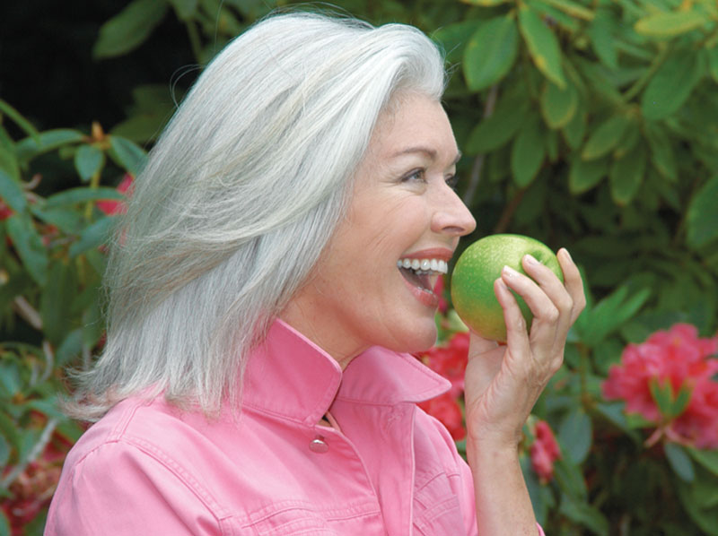 Lady eating and apple.