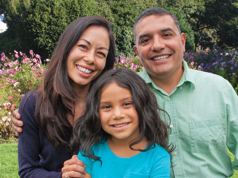 Mother, father and daughter in a garden.