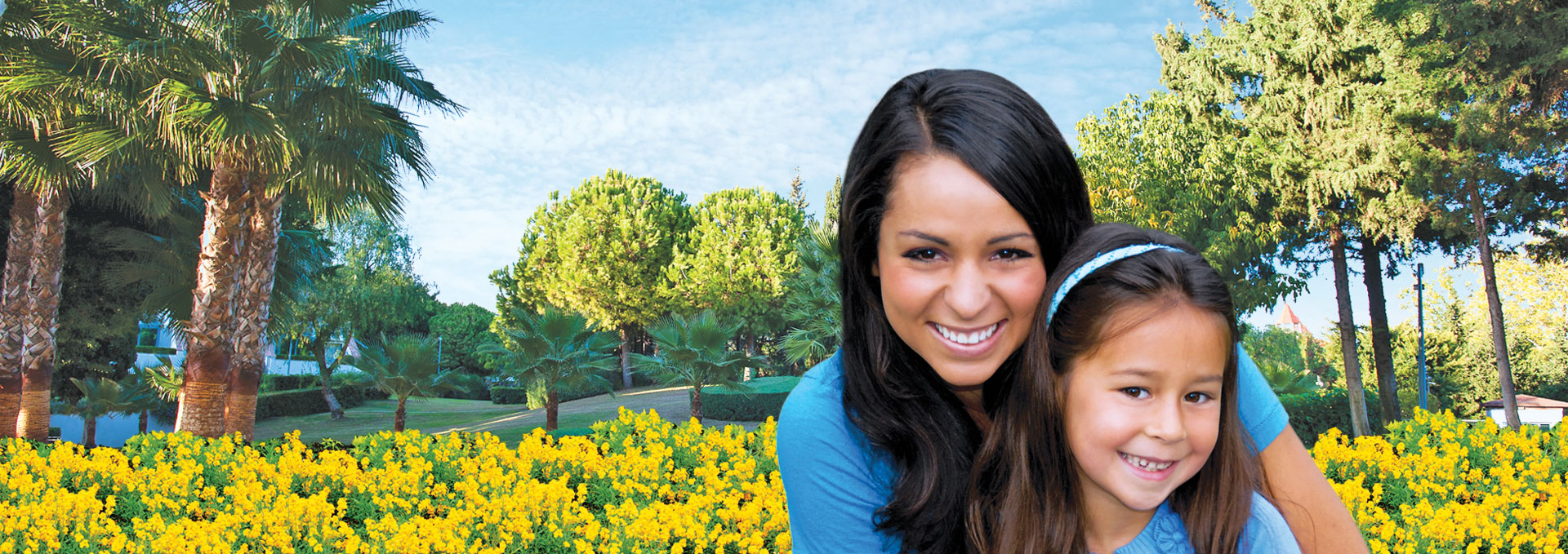 Mother and daughter smiling in a garden.
